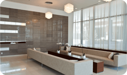 Modern lobby seating in front of tall, sheer-curtained windows