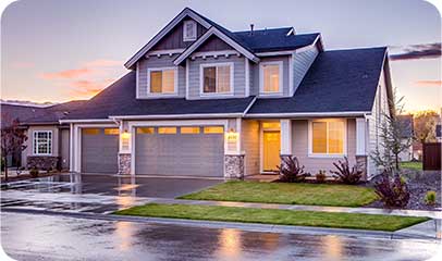 Two-storey suburban home lit from inside at dusk
