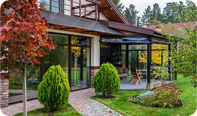 Glazed veranda on a house surrounded by an autumn garden